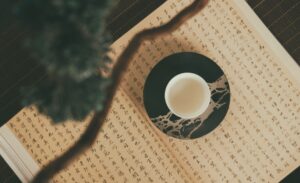 Photo of a tea cup on a book of Chinese calligraphy
