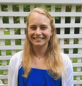 Picture of Lauren Raveret in blue shirt against lattice background