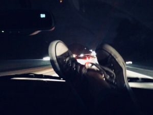 pair of hightops on a car dashboard